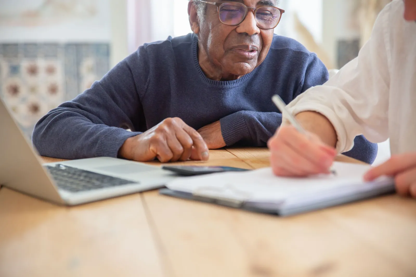 A support worker helps a man work through paperwork step by step